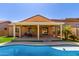 Backyard view of a pool and patio with artificial turf, with covered outdoor seating area at 346 E Red Mesa Trl, San Tan Valley, AZ 85143