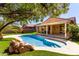 Beautiful pool with waterfall feature, covered patio, and landscaped backyard with artificial turf at 346 E Red Mesa Trl, San Tan Valley, AZ 85143