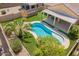 An aerial view of a private backyard pool, covered patio, artificial turf, and a desert landscape at 346 E Red Mesa Trl, San Tan Valley, AZ 85143