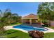 Backyard pool with rock feature, lush turf, patio, and desert landscaping for a relaxing outdoor space at 346 E Red Mesa Trl, San Tan Valley, AZ 85143