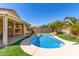 Sparkling pool with rock waterfall, lush landscaping, patio, and a covered outdoor living space at 346 E Red Mesa Trl, San Tan Valley, AZ 85143