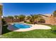 Backyard with a private pool, rock features, mature trees, landscaping, and artificial grass at 346 E Red Mesa Trl, San Tan Valley, AZ 85143