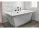 Clean, contemporary bathtub with black hardware, subway tile, and dark tile floors at 3483 E Bloomfield Pkwy, Gilbert, AZ 85296