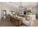 Open-concept dining area features modern decor and a long wooden table with chairs at 3483 E Bloomfield Pkwy, Gilbert, AZ 85296