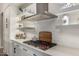 Gourmet kitchen featuring a modern gas range, floating shelves, and white brick backsplash at 3483 E Bloomfield Pkwy, Gilbert, AZ 85296
