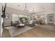 Spacious living room with an oversized sectional couch and modern chandeliers at 3483 E Bloomfield Pkwy, Gilbert, AZ 85296