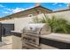 Modern outdoor kitchen with a built-in Coyote grill, perfect for outdoor cooking and entertaining guests at 3483 E Bloomfield Pkwy, Gilbert, AZ 85296