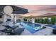 Stunning pool with a fire feature, adjacent spa, and shaded seating area, creating an ideal outdoor retreat at 3483 E Bloomfield Pkwy, Gilbert, AZ 85296