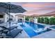 Beautiful pool area with a fire feature, spa, and umbrella, providing a perfect outdoor entertainment space at 3483 E Bloomfield Pkwy, Gilbert, AZ 85296
