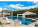 Luxurious swimming pool area with a stylish pavilion, water feature with a fire pit, and comfortable seating at 3483 E Bloomfield Pkwy, Gilbert, AZ 85296