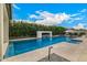Stunning swimming pool with a modern water feature, fire pit, and lush landscaping, perfect for relaxation at 3483 E Bloomfield Pkwy, Gilbert, AZ 85296