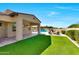 Backyard view with artificial grass and desert landscaping, with a partial view of the pool and spa at 35348 N 87Th St, Scottsdale, AZ 85266