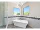 Modern bathroom featuring a freestanding tub, beautiful windows, and elegant tile work at 35348 N 87Th St, Scottsdale, AZ 85266