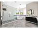 Modern bathroom featuring walk-in shower, soaking tub, hexagon tile floor, and large windows at 35348 N 87Th St, Scottsdale, AZ 85266