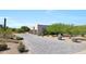 Expansive paver driveway leads to a desert home with a three-car garage and lush landscaping at 35348 N 87Th St, Scottsdale, AZ 85266