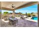Outdoor kitchen and dining area near a pool, with barbecue, chairs, and desert landscaping at 35348 N 87Th St, Scottsdale, AZ 85266
