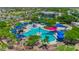 Aerial view of a vibrant water park with pools, slides, and colorful umbrellas, surrounded by mature trees at 3554 N Presidio Ct, Florence, AZ 85132