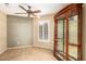 Bedroom featuring ceiling fan, tile floors, shuttered window and wooden cabinet at 3690 N 150Th Ave, Goodyear, AZ 85395
