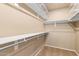 Walk-in closet with custom shelving, closet rods, and neutral carpeting at 3690 N 150Th Ave, Goodyear, AZ 85395