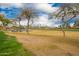Scenic view of the golf course with a pond, lush green grass, and homes in the distance at 3690 N 150Th Ave, Goodyear, AZ 85395