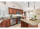 Well-equipped kitchen with stainless steel appliances, ample counter space, and cherry wood cabinetry at 3690 N 150Th Ave, Goodyear, AZ 85395