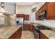 Spacious kitchen with granite countertops, stainless steel appliances, and custom wood cabinetry at 3690 N 150Th Ave, Goodyear, AZ 85395
