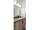 Modern bathroom vanity featuring a square mirror, gray countertop, and wood-grain cabinets with black hardware at 377 E Windsor Ave # 4, Phoenix, AZ 85004