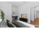 Bedroom featuring desk, TV, and hardwood floors; all bathed in natural light at 393 S Soledad Ln, Casa Grande, AZ 85194