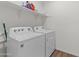 Functional laundry room with modern washer and dryer, and convenient shelf space for storage at 393 S Soledad Ln, Casa Grande, AZ 85194