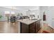 Open-concept kitchen flows into living and dining areas, featuring modern fixtures and wood flooring at 393 S Soledad Ln, Casa Grande, AZ 85194