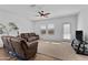 Cozy living room with plush brown couches, a ceiling fan, and plenty of natural light from the windows at 393 S Soledad Ln, Casa Grande, AZ 85194