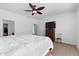 Well-lit main bedroom featuring carpet flooring, a ceiling fan, and a comfortable bed with white linens at 393 S Soledad Ln, Casa Grande, AZ 85194