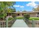 Expansive backyard with lush lawn, mature landscaping, and a charming bridge leading to the pool area at 4010 E Montebello Ave, Phoenix, AZ 85018