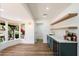 Bright bar area with wood floors, wine fridge, sleek blue cabinetry and stylish floating shelves at 4010 E Montebello Ave, Phoenix, AZ 85018