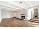 Cozy living room featuring a fireplace with a white brick surround and hardwood flooring at 4010 E Montebello Ave, Phoenix, AZ 85018