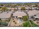 Aerial view of a beautiful home with a spacious backyard, desert landscaping, paver patio, seating, and mature trees at 4365 E Briles Rd, Phoenix, AZ 85050