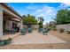 Open backyard with desert landscaping, BBQ grill, and patio set on a paved surface at 4365 E Briles Rd, Phoenix, AZ 85050