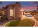 A view of the yard showing the house, landscaping, and refreshing pool area under a colorful sunset at 4614 W Fallen Leaf Ln, Glendale, AZ 85310