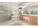 Luxurious bathroom with a glass-enclosed shower, soaking tub, and decorative tile details at 4614 W Fallen Leaf Ln, Glendale, AZ 85310
