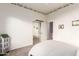 Bedroom with white walls, sliding mirror closet door, and doorway to an adjacent space at 4614 W Fallen Leaf Ln, Glendale, AZ 85310