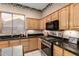 A kitchen featuring wood cabinets, black countertops, and stainless steel appliances at 4614 W Fallen Leaf Ln, Glendale, AZ 85310