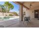 Covered patio area features a ceiling fan and overlooks the pristine pool and lush backyard at 4614 W Fallen Leaf Ln, Glendale, AZ 85310