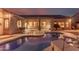Backyard view of a pool with covered patio at dusk at 4614 W Fallen Leaf Ln, Glendale, AZ 85310
