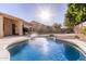 Sparkling pool with a water feature and tanning ledge, surrounded by a well-maintained backyard at 4614 W Fallen Leaf Ln, Glendale, AZ 85310
