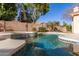 Backyard pool area with pristine blue water and integrated spa and lush surrounding landscape at 4614 W Fallen Leaf Ln, Glendale, AZ 85310