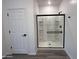 Modern bathroom featuring a glass-enclosed shower with black fixtures, and white walls, creating a clean and spa-like retreat at 47251 W Mellen Ln, Maricopa, AZ 85139
