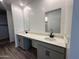Bathroom with dual vanities, white countertops and wood floors, providing style and functionality at 47251 W Mellen Ln, Maricopa, AZ 85139