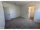 Carpeted bedroom with fresh paint, a closet door, and a bright view into the hallway at 47251 W Mellen Ln, Maricopa, AZ 85139