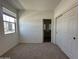 A well-lit bedroom with carpet, closet, window, and view into an en-suite bathroom at 47251 W Mellen Ln, Maricopa, AZ 85139
