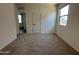 Carpeted bedroom with fresh paint, a hall access door, and a view to a large window at 47251 W Mellen Ln, Maricopa, AZ 85139